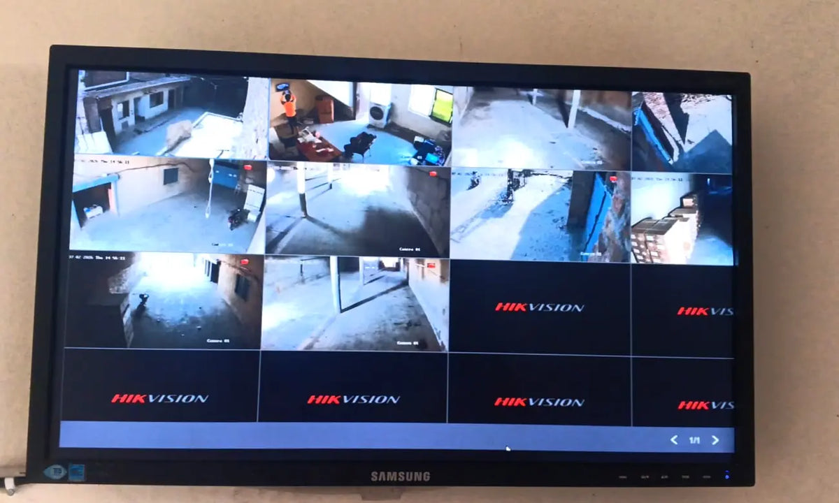 Hikvision recorder showing ten camera feeds on a wall-mounted screen, Luminey Pvt Ltd, Faisalabad